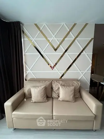 Modern living room with stylish geometric wall design and beige sofa