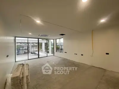 Spacious unfinished room with large windows and outdoor view, ideal for customization.