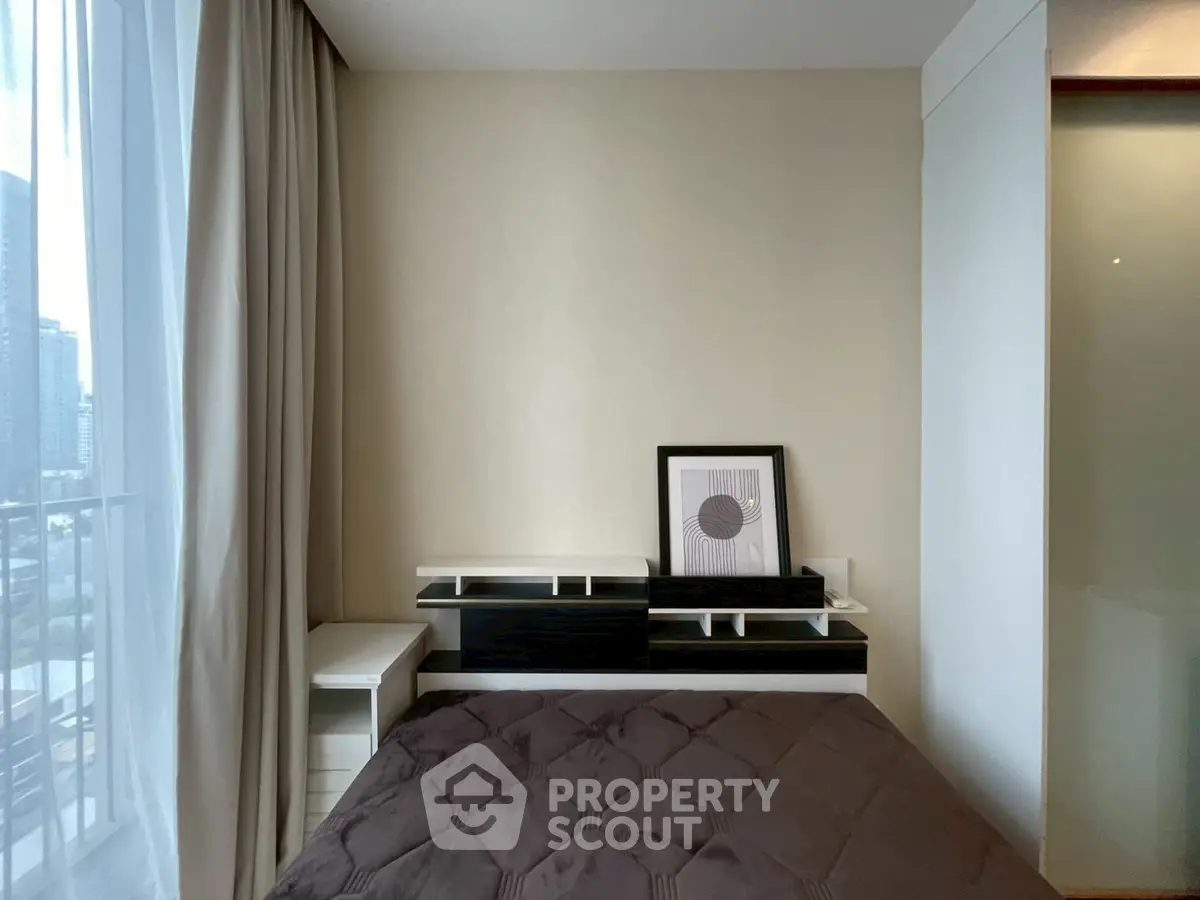 Modern bedroom with stylish decor and city view, featuring a cozy bed and elegant furnishings.