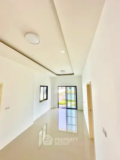 Spacious modern living room with sleek design and large window for natural light.