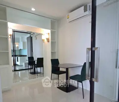 Modern dining area with sleek table and chairs, featuring built-in shelving and air conditioning.