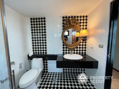 Luxurious bathroom with elegant black and white checkered tiles and ornate mirror