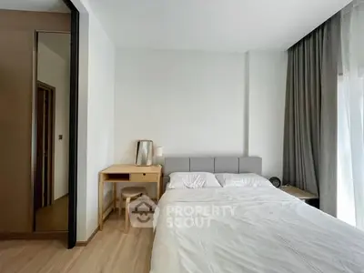 Modern bedroom with minimalist design, featuring a cozy bed, wooden desk, and floor-to-ceiling curtains.