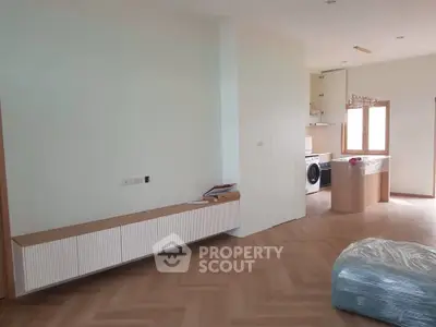 Spacious modern living room with elegant wooden flooring and stylish built-in storage.