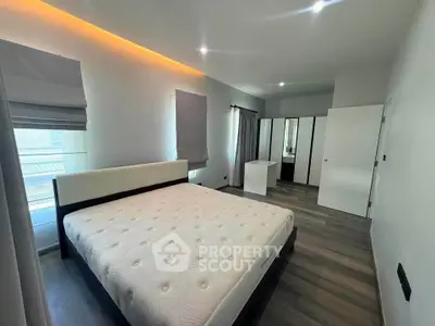 Spacious modern bedroom with elegant lighting and ample storage space