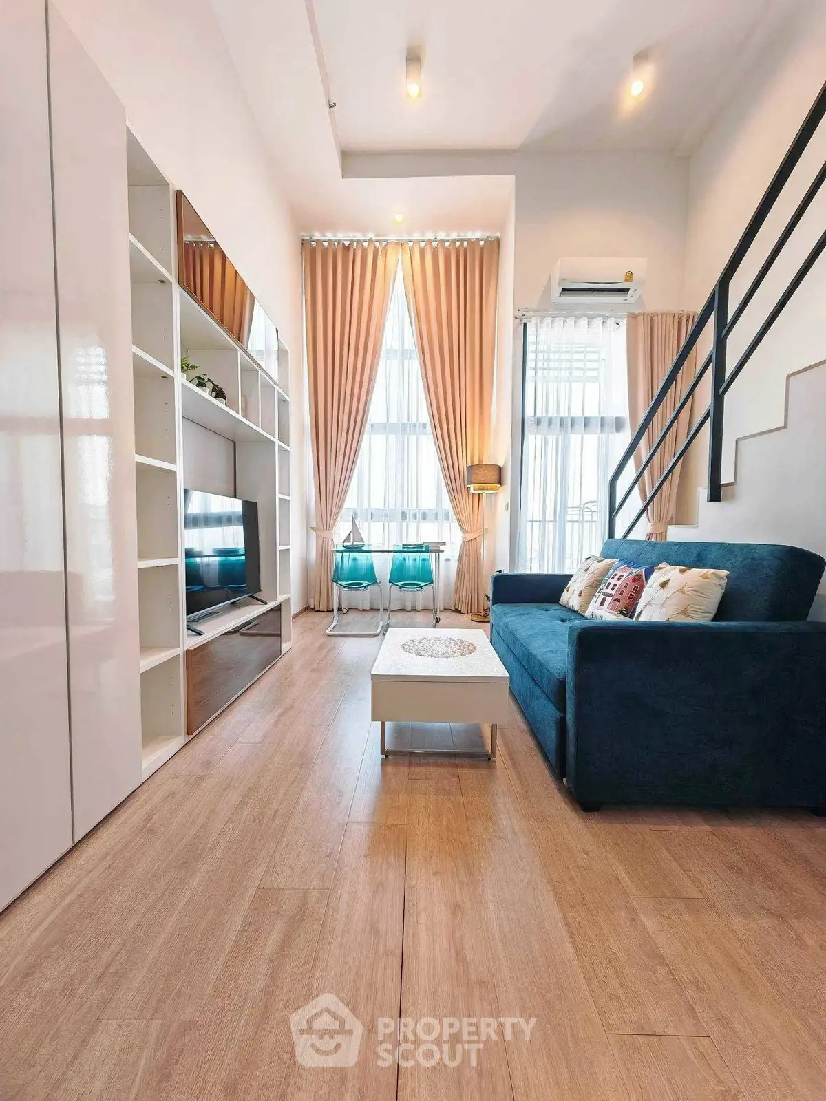 Modern living room with high ceilings, elegant curtains, and stylish furniture.