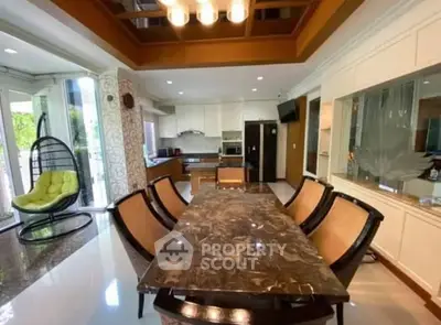 Luxurious dining area with marble table and modern kitchen in open layout design.