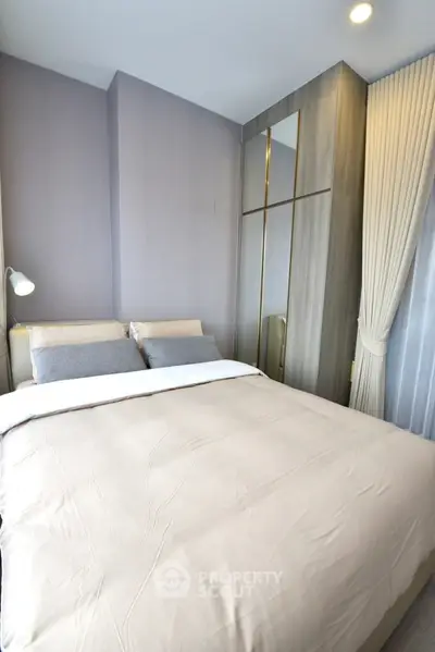 Modern bedroom with sleek wardrobe and cozy bedding in a stylish apartment.