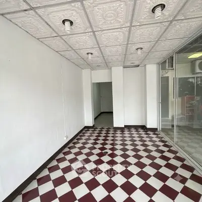 Spacious interior with checkered floor and decorative ceiling tiles, ideal for creative design opportunities.