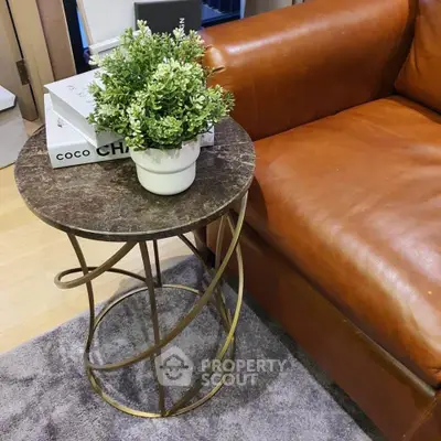 Stylish living room with elegant leather sofa and chic marble side table, perfect for modern interiors.
