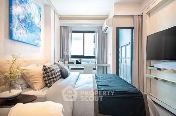 Modern bedroom with stylish decor and large window offering natural light.