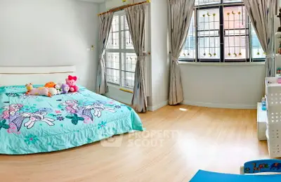 Charming bedroom with playful decor and ample natural light, perfect for a cozy retreat.