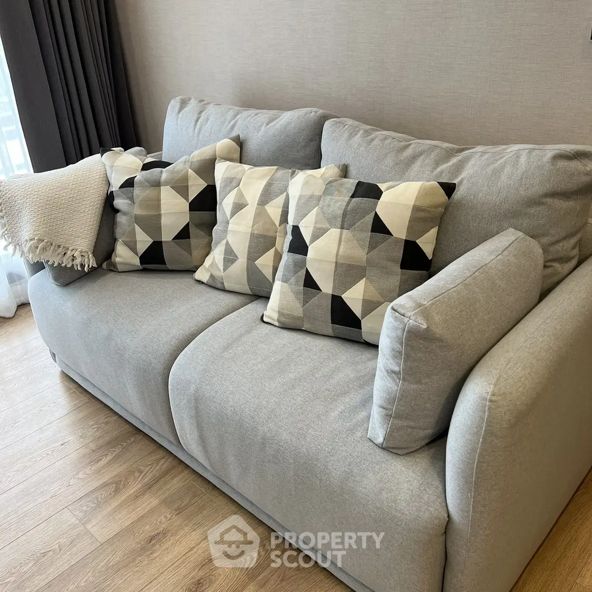 Cozy modern living room with stylish geometric pillows on a plush gray sofa.
