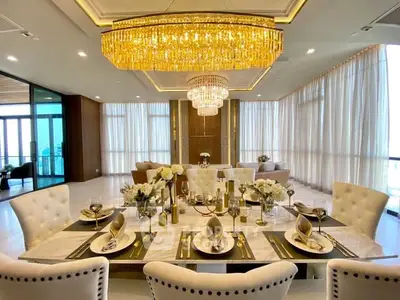 Luxurious dining room with elegant chandelier and beautifully set table in a modern apartment.