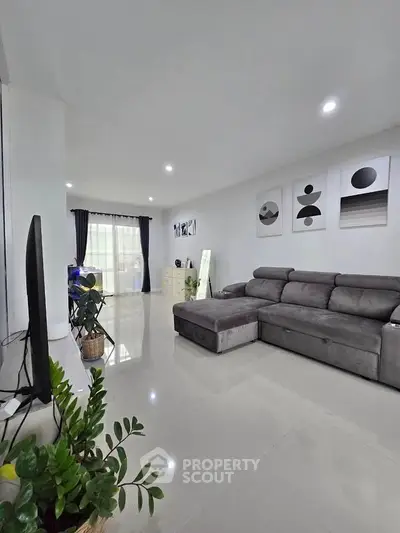 Spacious modern living room with sleek gray sofa and stylish decor, perfect for relaxation and entertainment.