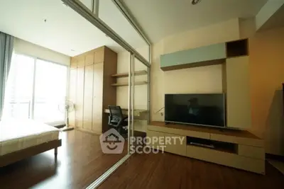 Modern bedroom with study area and large TV in stylish apartment