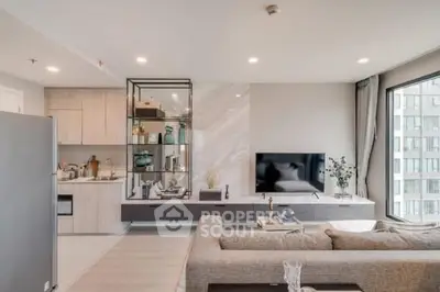 Modern living room with open kitchen, stylish decor, and large window view in a contemporary apartment.
