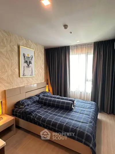 Modern bedroom with stylish decor and large window for natural light.