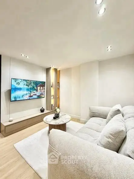 Modern living room with cozy sofa and wall-mounted TV, perfect for relaxation.