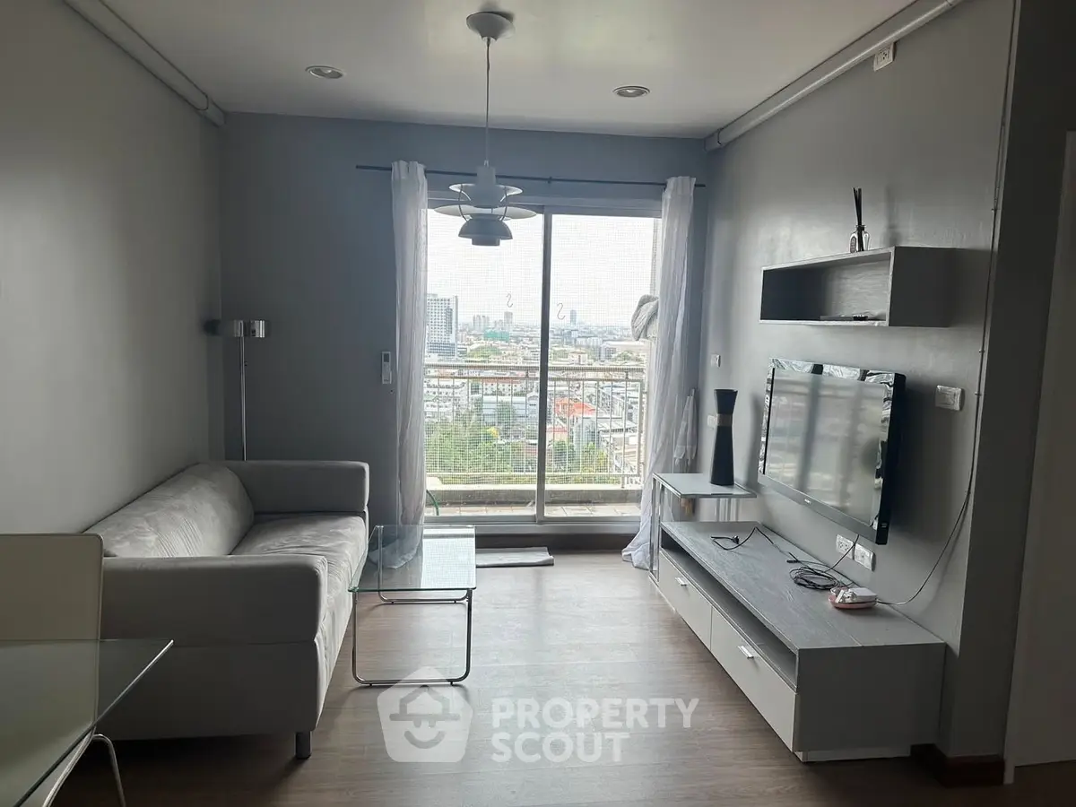 Modern living room with city view, featuring sleek furniture and large window for natural light.