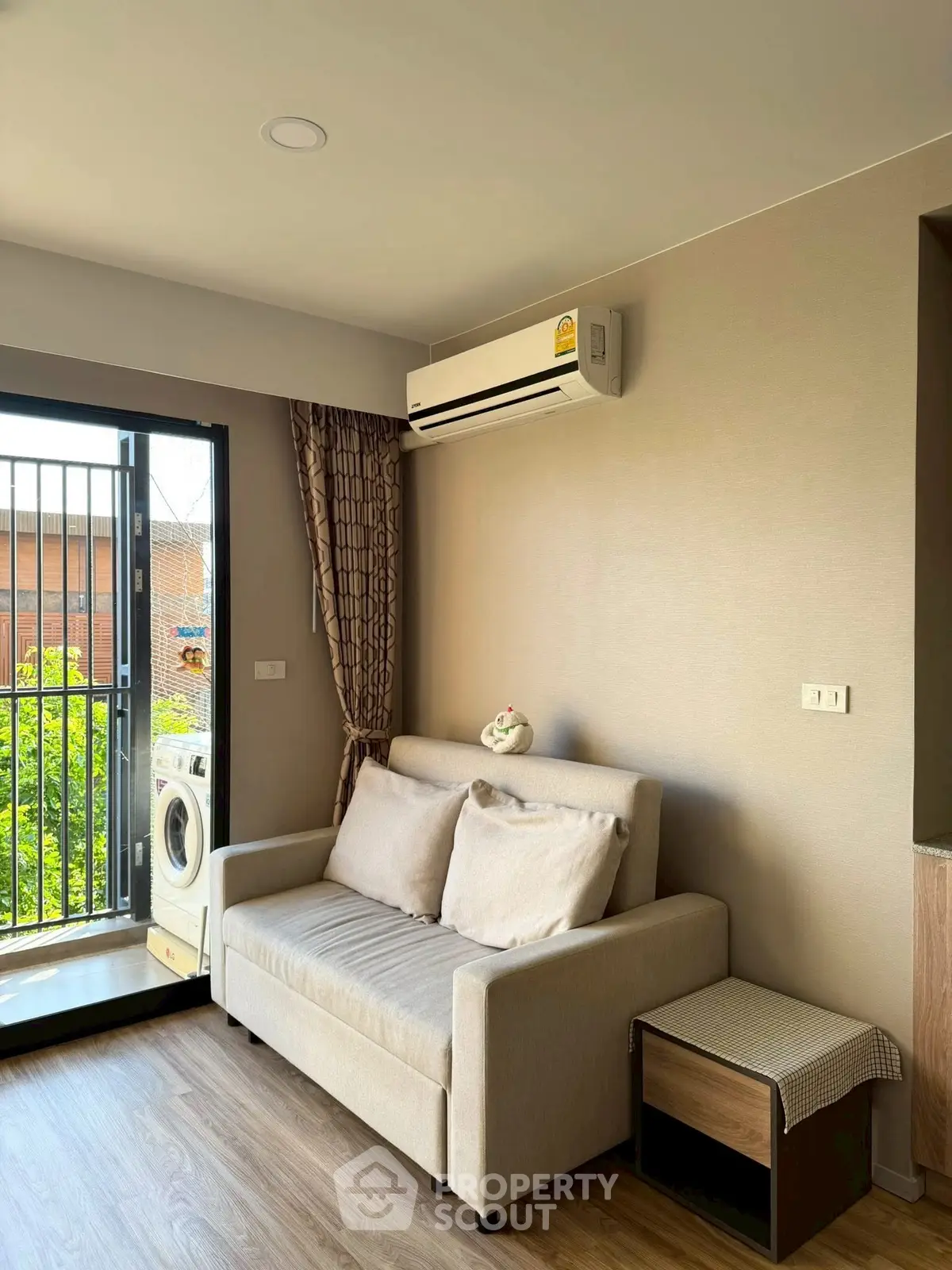 Cozy living room with sofa, air conditioning, and balcony view