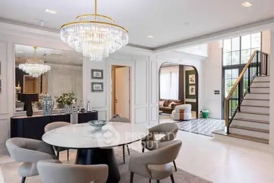 Luxurious open-plan living and dining area with elegant chandeliers and modern decor.