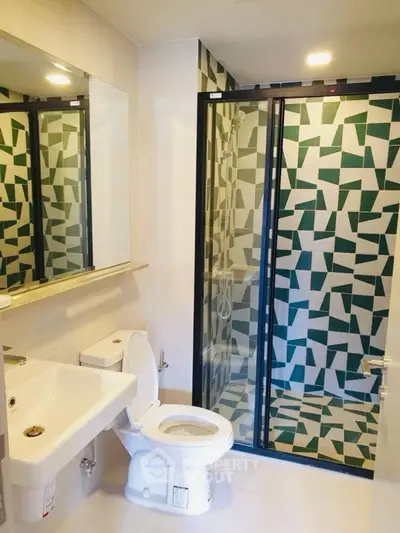 Modern bathroom with geometric tile shower and sleek fixtures