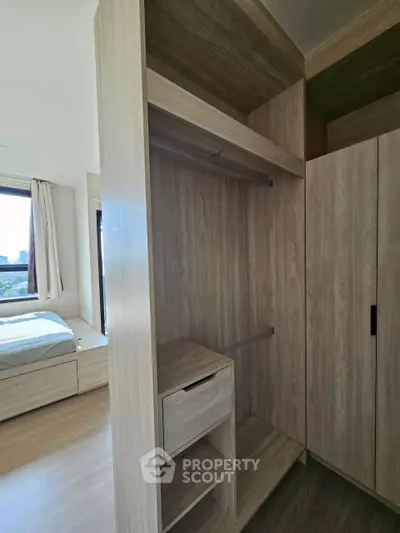 Spacious bedroom with modern wooden walk-in closet and large window view.