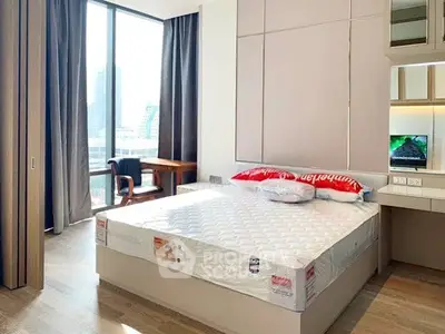 Modern bedroom with large window and city view, featuring a comfortable bed and stylish decor.