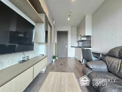 Modern living room with sleek furniture and open kitchen layout in a stylish apartment.