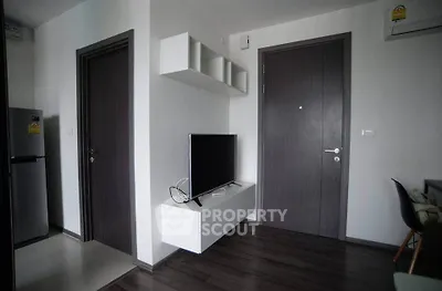 Modern apartment interior with sleek TV setup and stylish dark wood flooring.