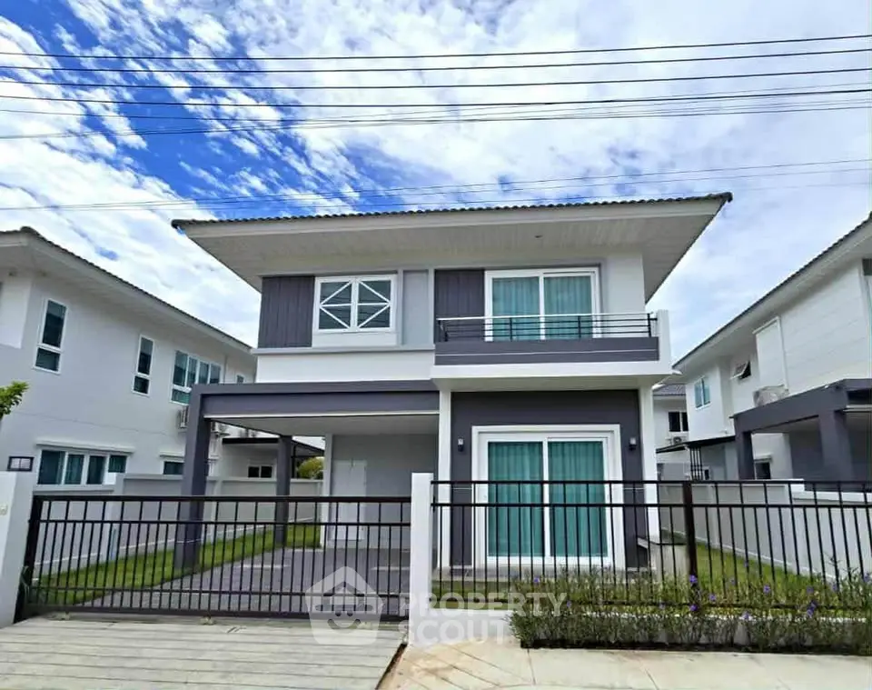 Modern two-story house with sleek design and spacious driveway in a suburban neighborhood.