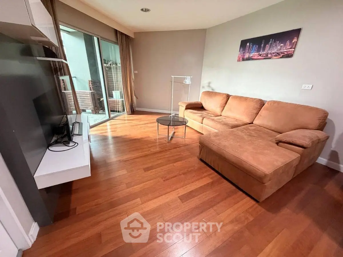 Spacious living room with modern furniture and balcony access in a stylish apartment.
