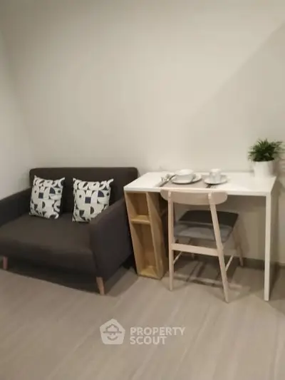 Cozy living area with modern sofa and dining table in compact apartment.