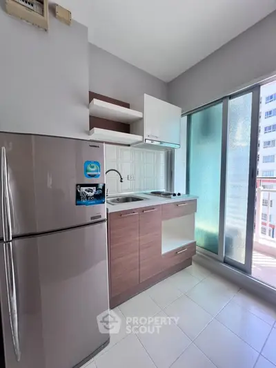 Modern compact kitchen with sleek appliances and balcony view