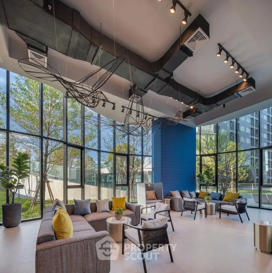 Modern living room with large windows and stylish furniture in a contemporary building.