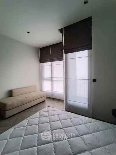 Spacious bedroom with modern decor and large windows for natural light.