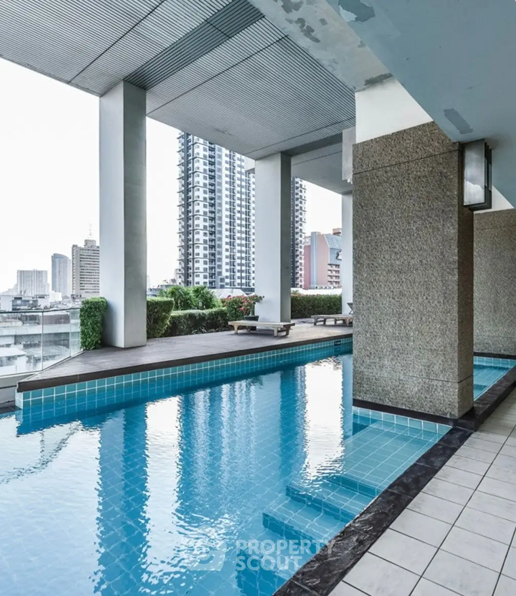 Luxurious rooftop pool with stunning city views in modern high-rise building.