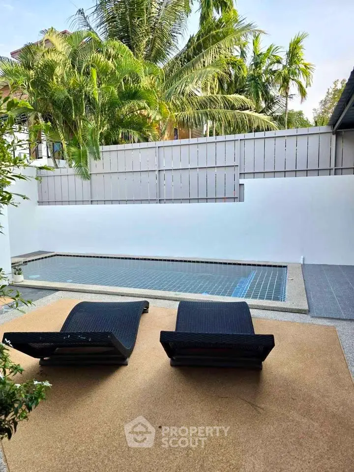 Luxurious private pool area with sun loungers and lush greenery, perfect for relaxation and leisure.