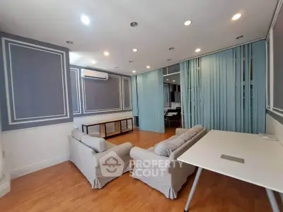 Spacious living room with elegant decor and ample natural light, perfect for relaxation.