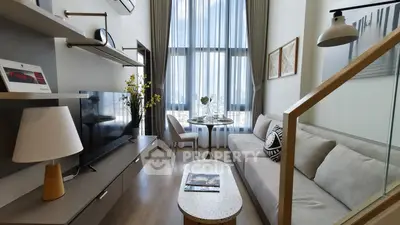 Modern living room with high ceilings, large windows, and stylish decor in a contemporary apartment.