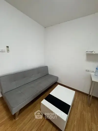 Cozy minimalist living room with gray sofa and modern coffee table.