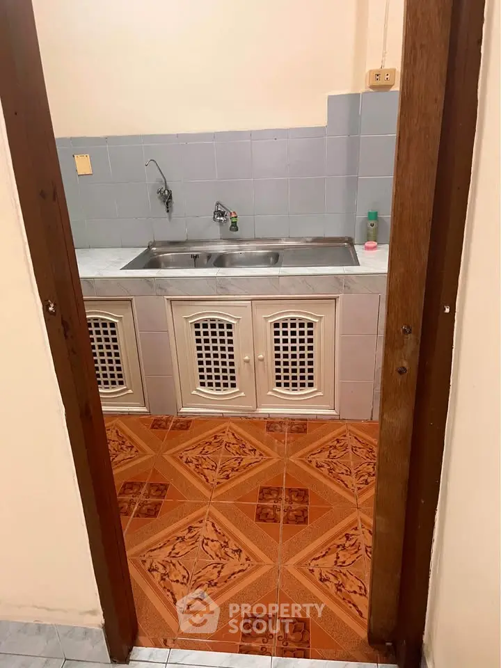 Charming kitchen with unique tile flooring and classic cabinetry, perfect for cozy home cooking.