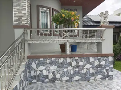 Charming exterior with decorative tiles and garden view, featuring a quaint balcony and artistic sculptures.