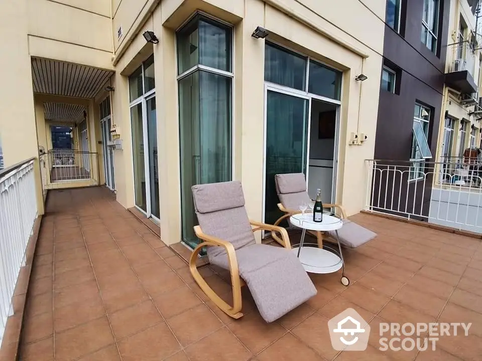 Spacious balcony with modern lounge chairs and table, perfect for relaxation and outdoor enjoyment.