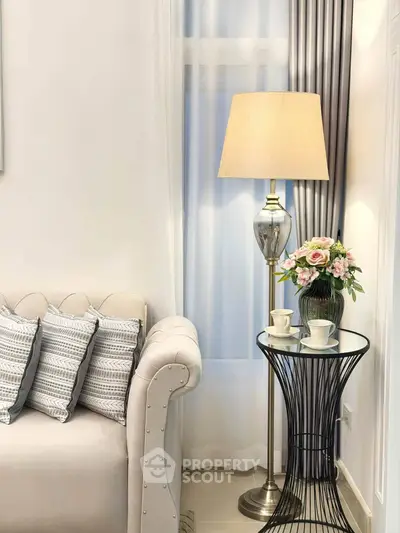 Elegant living room corner with plush sofa, stylish lamp, and chic side table for cozy ambiance.