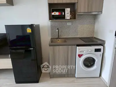 Modern compact kitchen with fridge, microwave, and washing machine