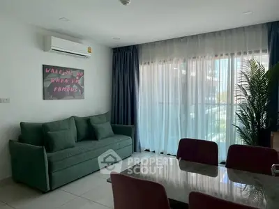 Modern living room with green sofa and large window, perfect for relaxation.