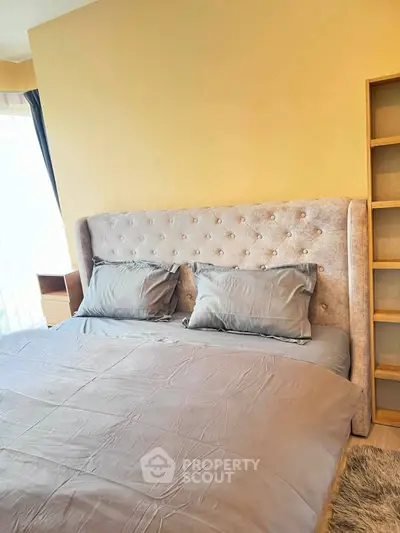 Luxurious bedroom with plush headboard and elegant bedding in modern apartment
