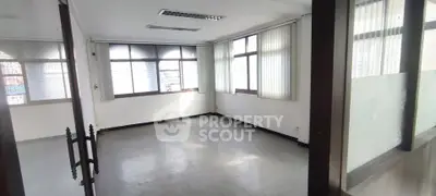 Spacious office space with large windows and ample natural light, ideal for professional use.